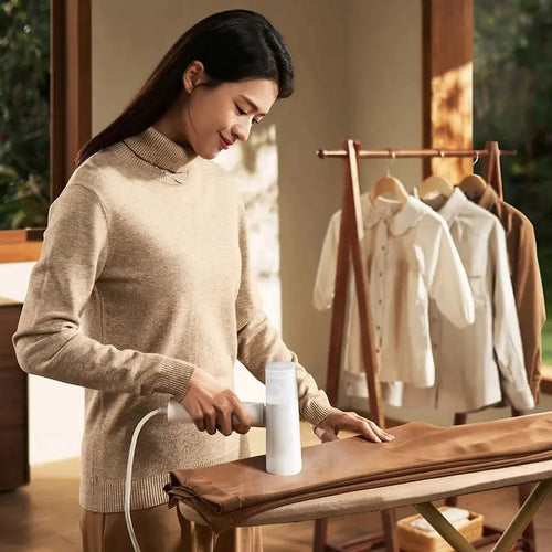 Compact travel steam iron showing the handle folded down into a space-saving shape.